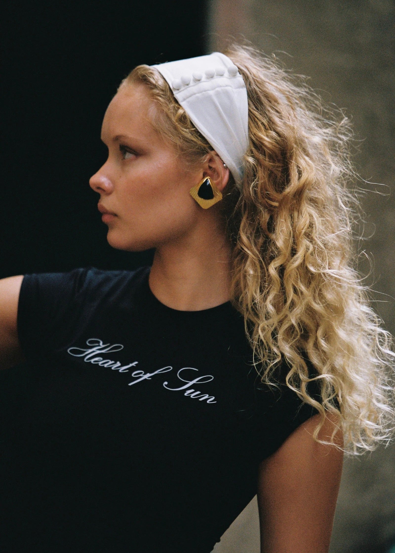 Model wearing the Penelope Headband in Ivory, with satin buttons, adding a touch of sophistication to any outfit.