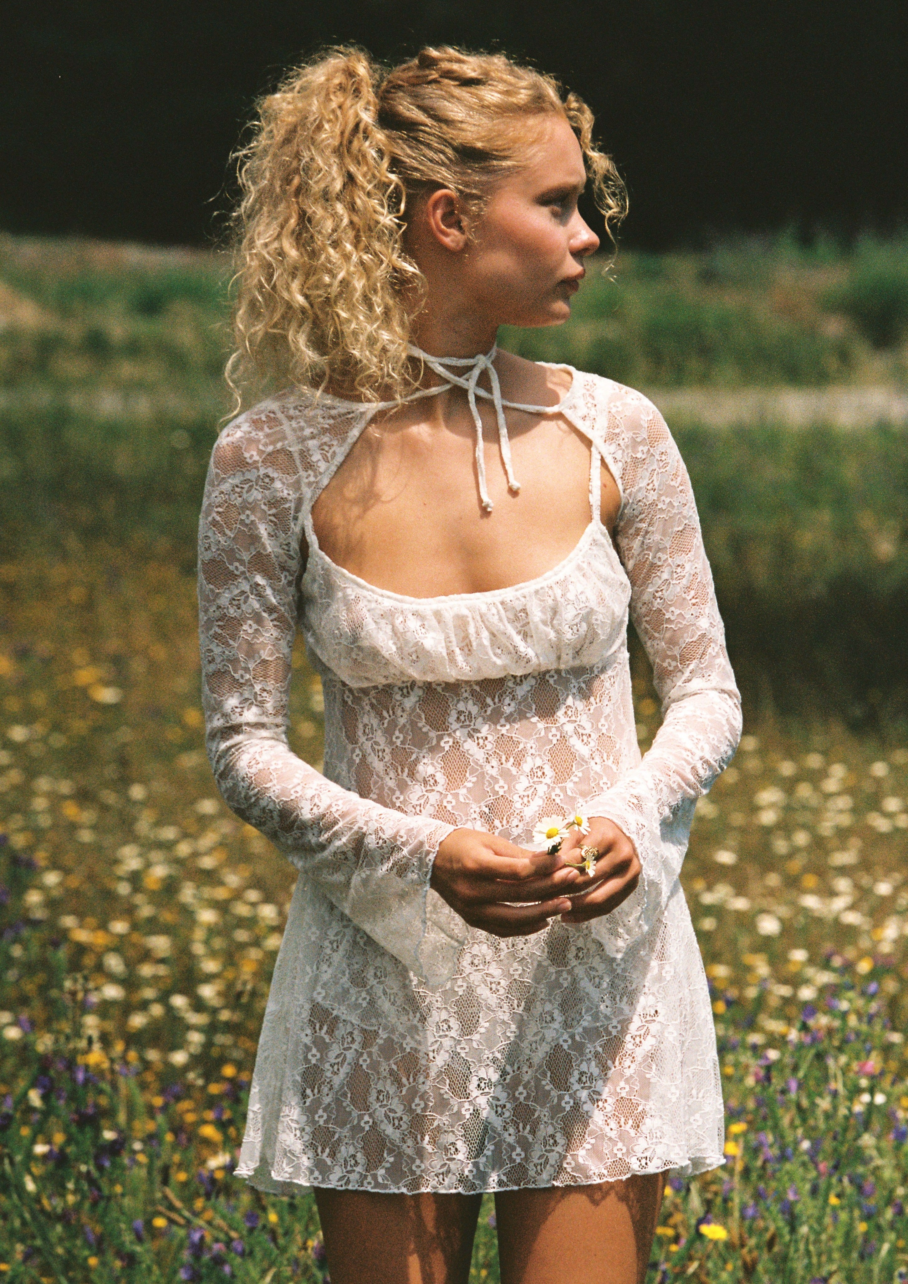 Model posing in the Bisou lace bolero with bell sleeves, styled with a summer dress for a relaxed yet elegant look