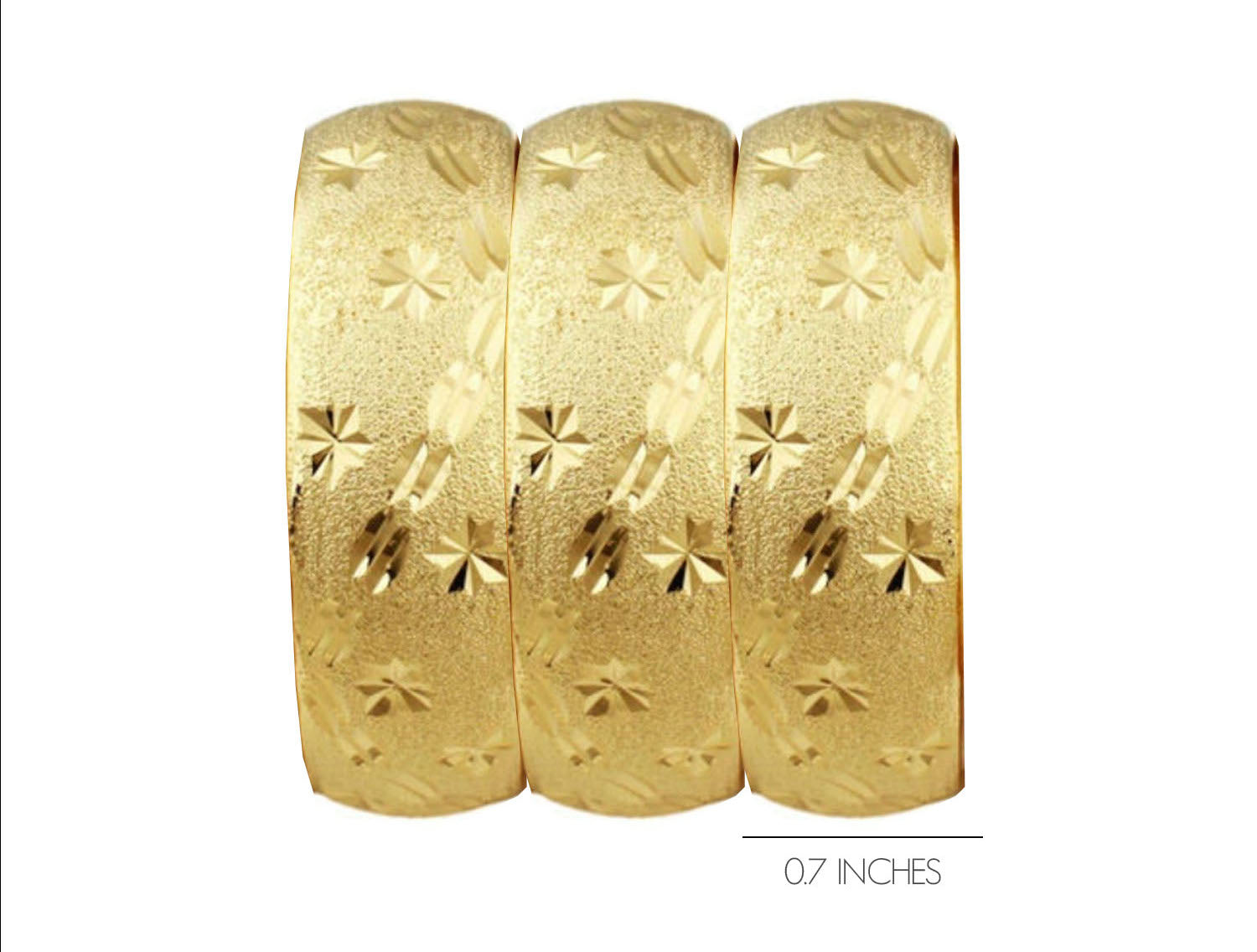 Close up of 18k gold slip on bangle set featuring intricate starburst engravings.