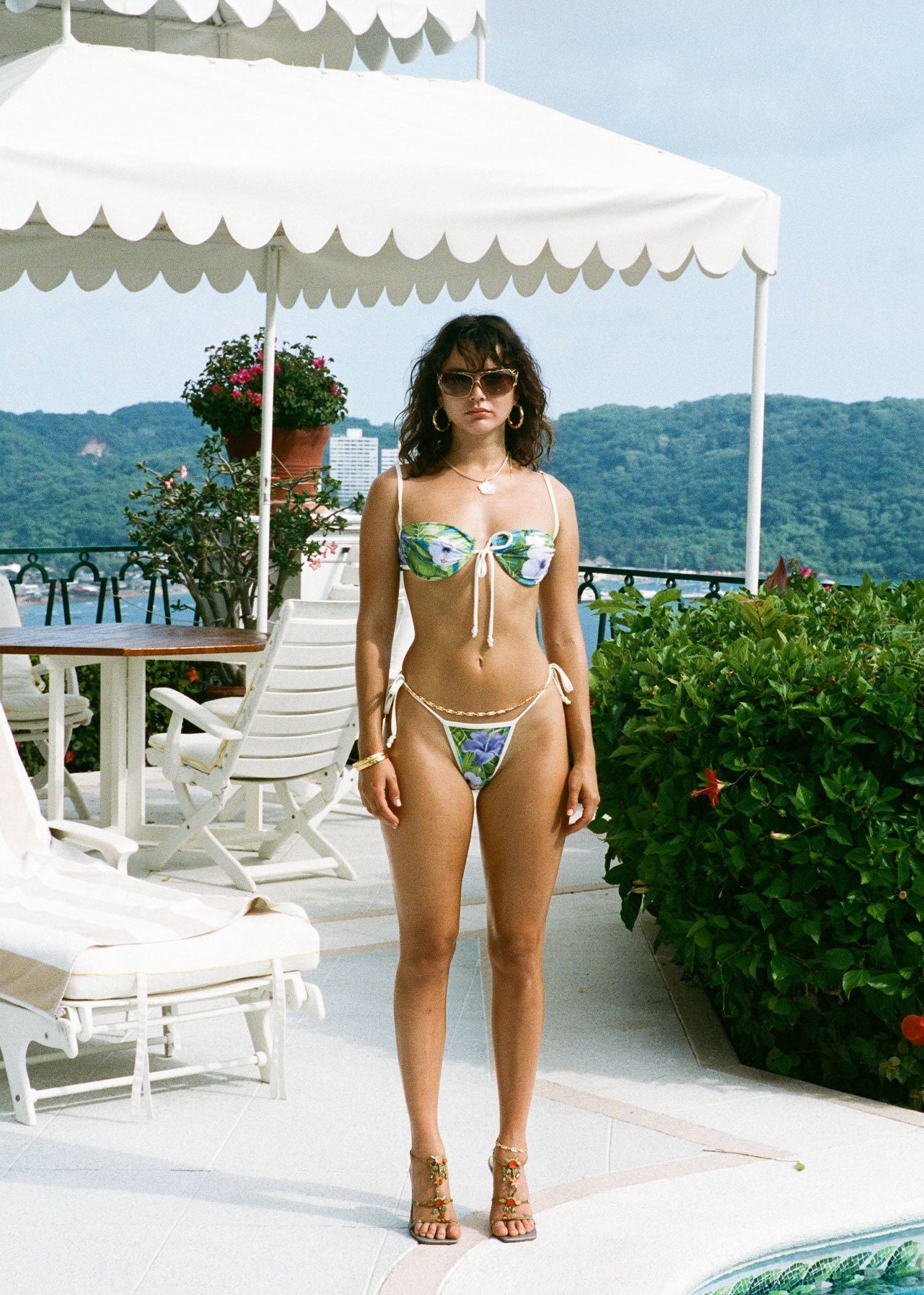 Model posing in a floral bikini featuring the bottoms cheeky coverage and high-waisted fit.