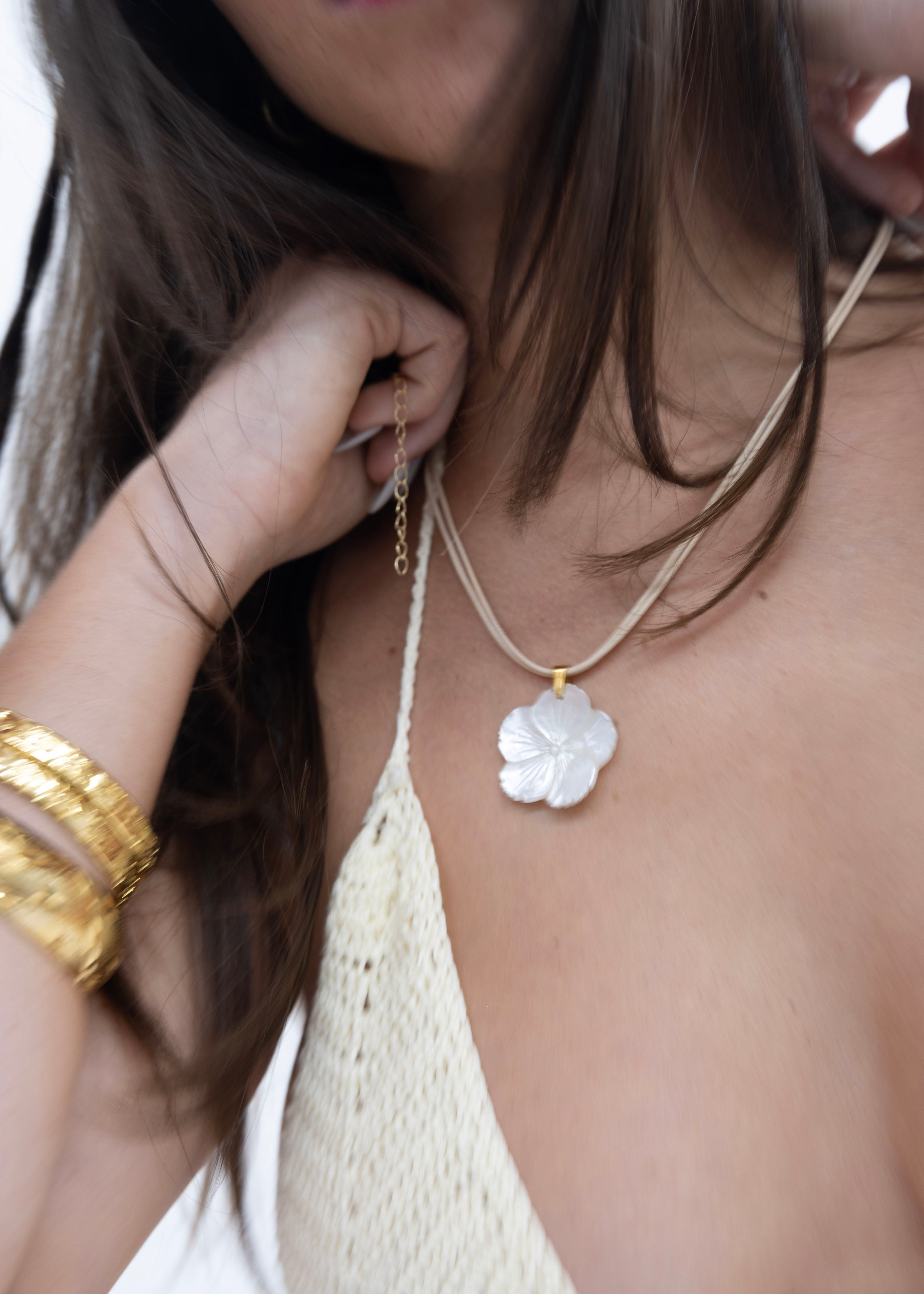 Model wearing a white double rope choker with a freshwater pearl pendant. 