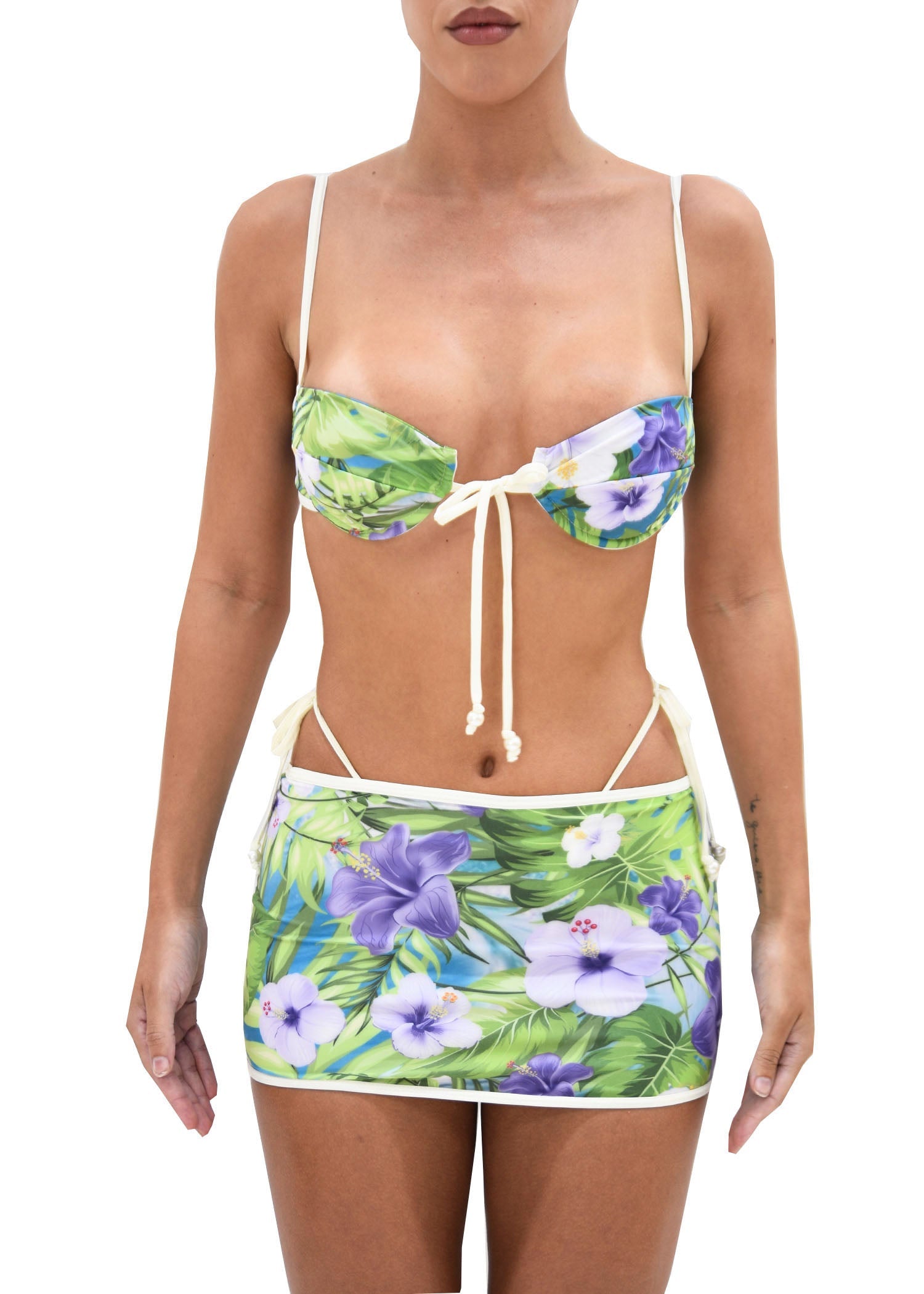 Model wearing a floral print bikini with matching mini skirt featuring its luxe Italian fabric. 