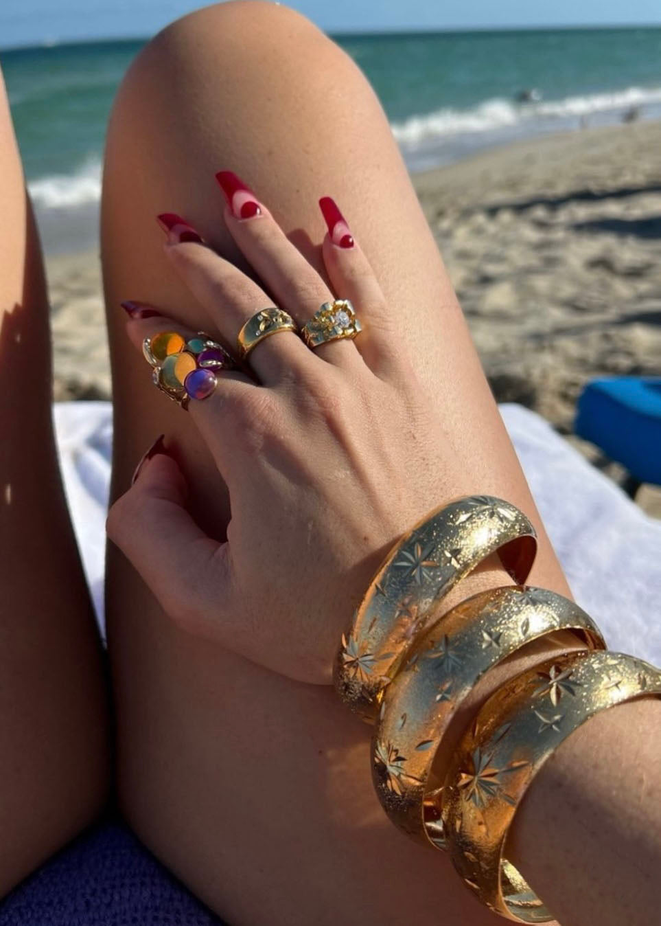 Close up of 18k gold slip on bangle set featuring intricate starburst engravings. 